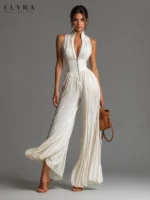 White Pleated Jumpsuit by ELYRA LABEL featuring a stand collar, front zipper, sleeveless design, high waist, and flowing wide-leg silhouette