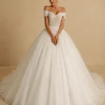 Princess Ball Gown Wedding Dress by ELYRA LABEL featuring an off-shoulder sweetheart neckline, glitter embroidered organza and tulle, appliqué beading, lace-up back, and elegant floor-length ball gown silhouette.